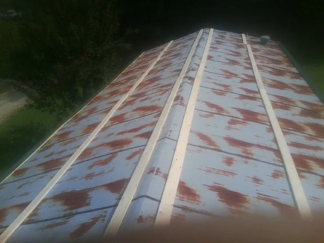 Rusted metal roof panels with new wood purlins before replacement — Storm Damage Roof Repair in El Dorado by Roofing Brothers