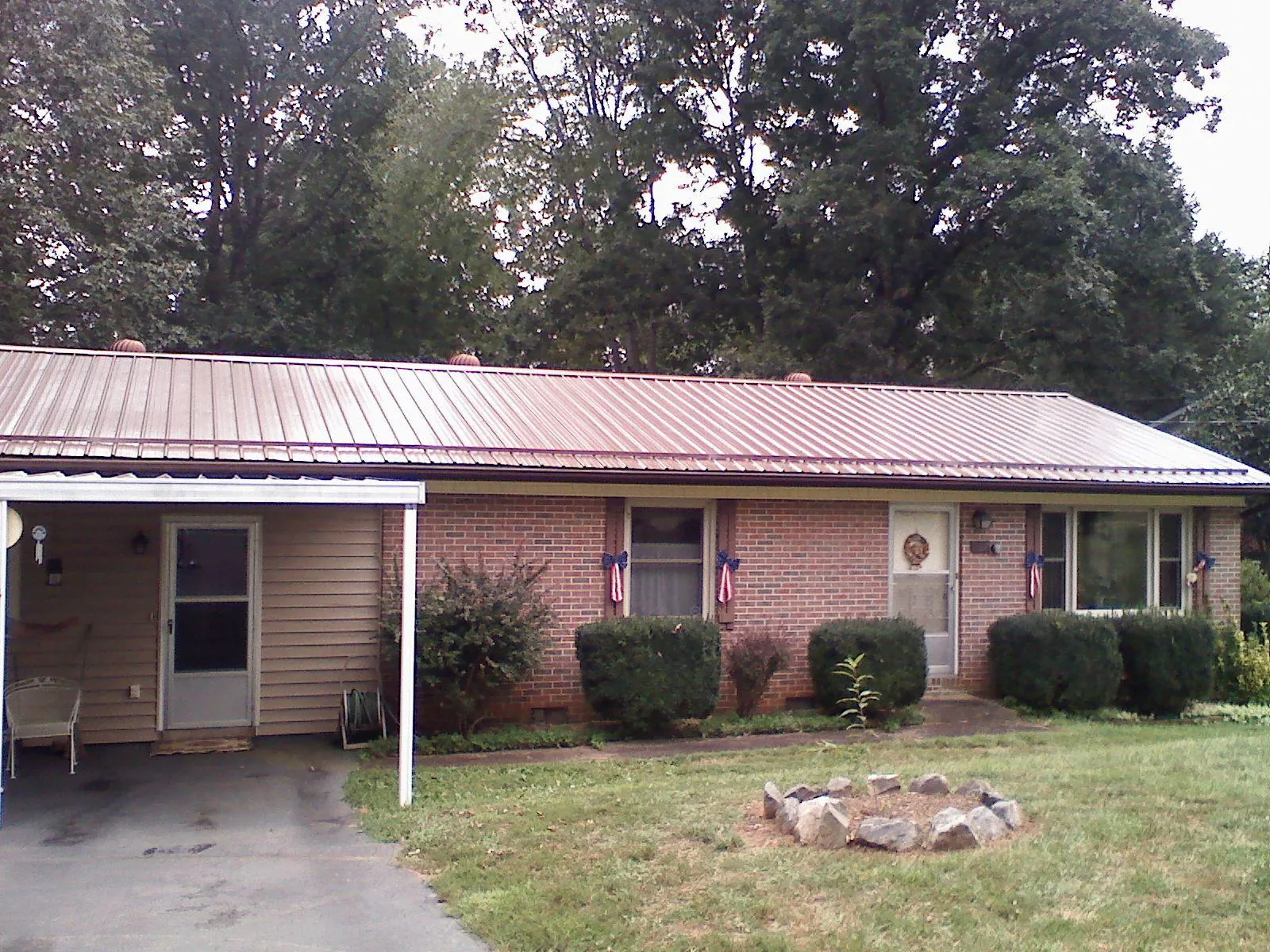 Bronze metal roof and carport on a brick ranch home — Roof Repair work by our crew in El Dorado